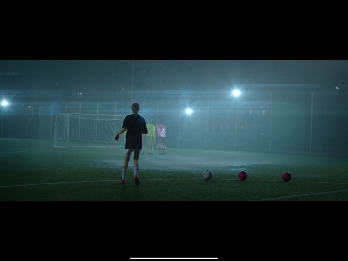 Soccer player training under floodlights at night